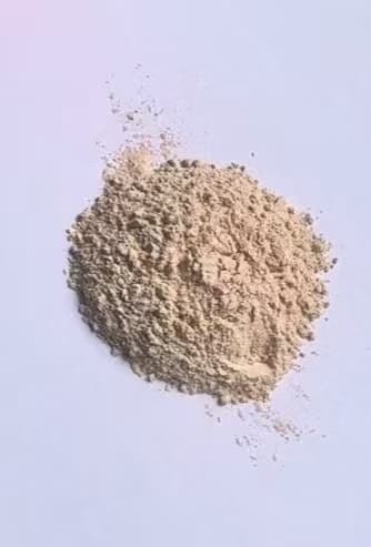 Magnesium oxide: pale beige powder on a white surface