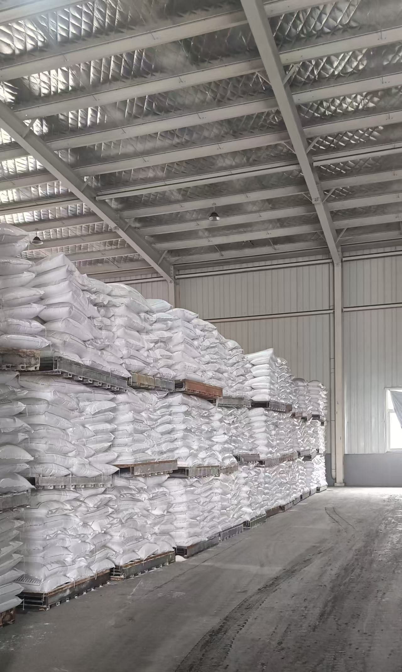 Sacks of anhydrous magnesium sulfate stacked on pallets in the warehouse
